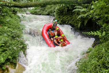 Pangalengan, Bandung-Endonezya Aralık 2022: Bir grup erkek ve kadın nehir üzerinde rafting yapıyorlar, ekstrem ve eğlenceli spor. Bir grup insan su sporları rafting