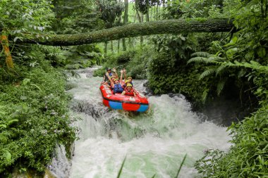 Pangalengan, Bandung-Endonezya Aralık 2022: Bir grup erkek ve kadın nehir üzerinde rafting yapıyorlar, ekstrem ve eğlenceli spor. Bir grup insan su sporları rafting