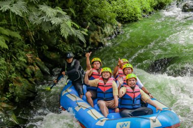 Pangalengan, Bandung-Endonezya Aralık 2022: Bir grup erkek ve kadın nehir üzerinde rafting yapıyorlar, ekstrem ve eğlenceli spor. Bir grup insan su sporları rafting