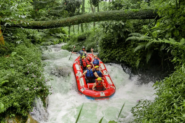 Pangalengan, Bandung-Endonezya Aralık 2022: Bir grup erkek ve kadın nehir üzerinde rafting yapıyorlar, ekstrem ve eğlenceli spor. Bir grup insan su sporları rafting