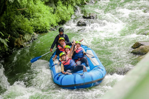 Pangalengan, Bandung-Endonezya Aralık 2022: Bir grup erkek ve kadın nehir üzerinde rafting yapıyorlar, ekstrem ve eğlenceli spor. Bir grup insan su sporları rafting