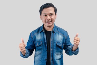 Genç Asyalı adam onay veriyor, tavsiye ediyor, tıpkı beyaz arka planda durmak gibi.