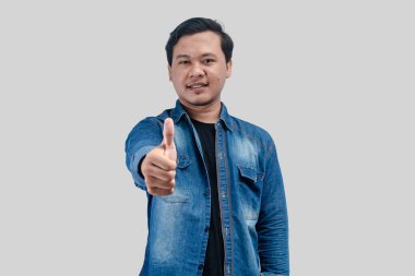 Genç Asyalı adam onay veriyor, tavsiye ediyor, tıpkı beyaz arka planda durmak gibi.