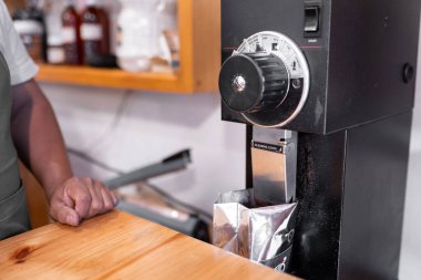 İspanyol bir adam bir poşetin öğütülmüş kahveyle dolmasını bekliyor. Yerel kahve üretimi kavramı