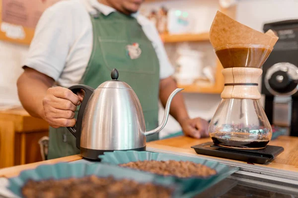 İspanyol bir barista filtrelenmiş kahve yapmak için su ısıtıcısı tutuyor. Yerel kahve üretimi kavramı