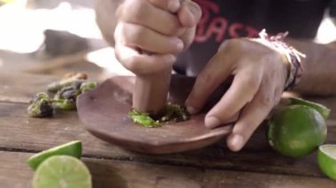 İspanyol bir genç adam havan topu ile biber ve limon sosu hazırlıyor. Geleneksel Meksika gastronomisi kavramı