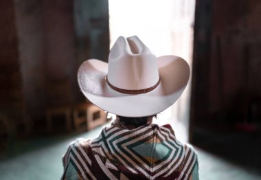 Tanımlanamayan genç bir Meksikalı kapının önünde şapka ve panço giyerek bekliyor. Batı sahnesi kavramı