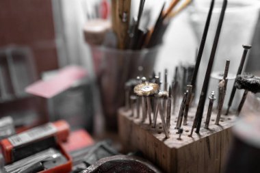 Bazı matkap metal fırçalar bir kuyumcu atölye çalışma masasında dinleniyor. El işi kavramı