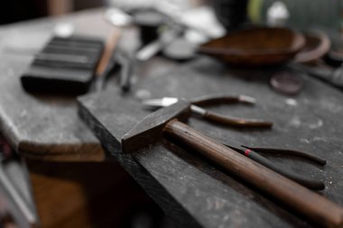 Üç el yapımı bilezik kuyumcunun çalışma masasının üzerinde duruyor. Latince el işi kavramı