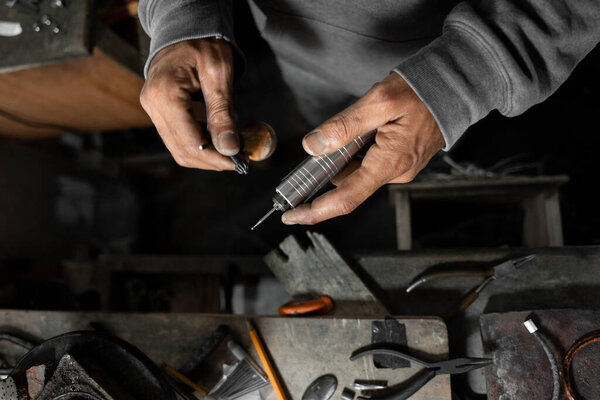 A craftsman jeweler is adjusting the drill to craft a jewel. Concept of craft work