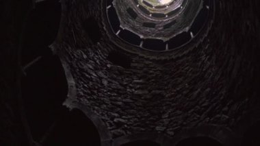 Portekiz 'in Quinta da Regaleira kentindeki eski bir kuyunun dibinden manzarayı izleyin. Seyahat kavramı