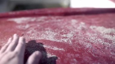 Teknenin üzerindeki kumu temizleyen bir elin kapağı. Yaz atmosferi kavramı