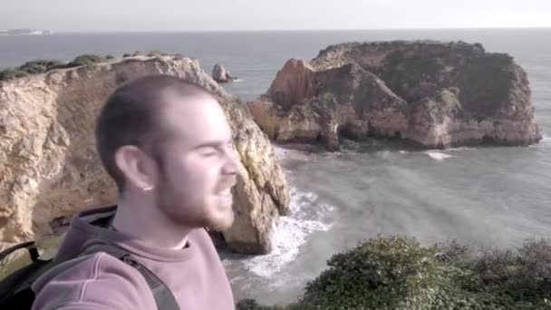 若い男がポルトガルのアルガルヴェのジョアオ アレス海岸で話している自分自身を撮影しています コンテンツ作成者の概念 — ストック動画