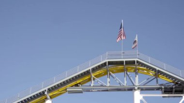 Santa Monica İskelesi hız treninde ABD ve Kaliforniya bayrakları. Kapatın. Los Angeles 'ın popüler mekanları kavramı