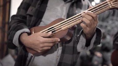 A mexican male musician playing a bass jarana guitar in a traditional music jam session. Concept of traditional folk music in Mexico