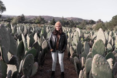 Portrait of a young woman model posing in a nopal field during the sunrise. Concept of mexican fashion
