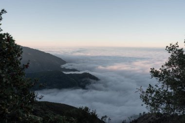 A landscape above the clouds from the top of a mountain during the sunset in the coast of California. Big Sur. Concept of coast road trip