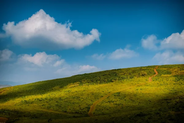 Gökyüzünde kabarık bulut oluşumuyla güzel tepe istasyonu.
