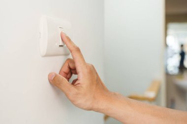 Closeup of finger is turning off on lighting switch on white wall at home. Power, Energy, Saving Electrical, Copy space.