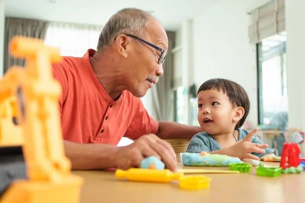 Portret Azjatyckiego Dziadka Bawiącego Się Wnukiem Podczas Robienia Zabawek Plastycyny — Zdjęcie stockowe