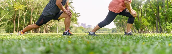 Asian Senior man and woman Legs doing exercise at park. Elderly couple enjoying workout at outdoor in the morning. Mature Adult relaxing and stretching in nature. Panoramic, Banner.