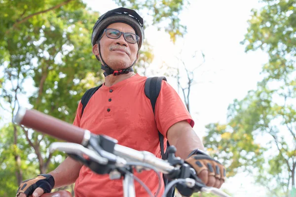 stock image Active Asian Chinese Senior man travel with bicycle in a park outdoors. Retirement activity, Relax, Exercise, wellness and lifestyle