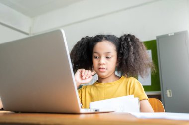 Saçları örgülü, dizüstü bilgisayarla çalışan Afrikalı Amerikalı ilkokul öğrencisi. İnternet, Modern Sınıf, Eğitim, Çevrimiçi Öğrenme, E-Öğrenme Konsepti