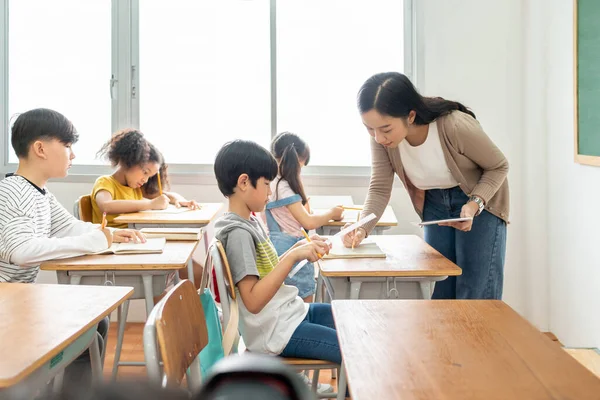 Азиатская Учительница Говорит Помогает Ученикам Учиться Партами Классе Начальной Школы — стоковое фото