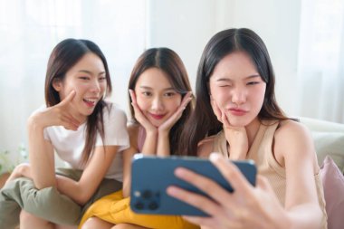 Üç Mutlu Gülümseyen Asyalı Genç Kadın 'ın portresi akıllı telefonla selfie çekiyor. Neşeli etnik çeşitlilik insanları. Korece, Çince, Japon kız arkadaşlığı.