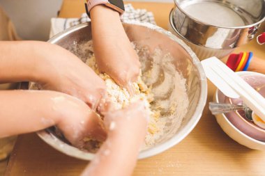 Yakın çekim annesi ve küçük oğlu birlikte hamur işi pişiriyorlar. Pasta ve kurabiye hazırlamak, örgü örmek, yemek pişirmek, ev yapımı.