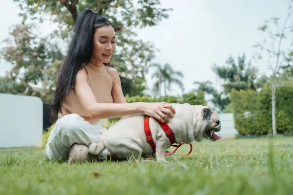 Genç Asyalı Bir Kadın Köpeğini Yemyeşil Bir Bahçede Okşuyor Açık Stok Resim