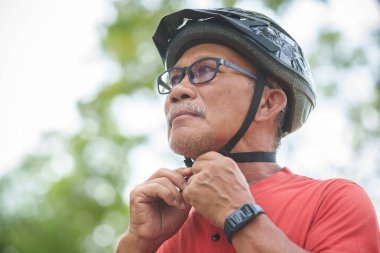 Bisiklet Miğferini Ayarlayan Asyalı Son Sınıfın Portresi Bisiklet, Gözlük, Turuncu ya da Kırmızı Gömlek Hazırlamak İçin Açık havada