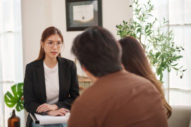 Asyalı kadın danışman, genç bir çiftle düşünceli bir tartışmaya girer ve ofiste ilişki planlaması ve duygusal refahı hakkında fikir verir..