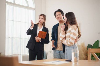 Asyalı çift, modern bir konutu keşfederken bir emlakçıyla ev satın alma ve finansal planlama hakkında ayrıntılı bir tartışmaya giriştiler.