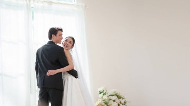 Mutlu Asyalı gelin ve damat düğün anının tadını çıkarın. Gelin stüdyoya buket atıyor..