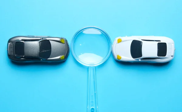 拡大鏡の洞察力を持つ2台の小型車のフラットレイアウト画像 最高の車の取引の概念 — ストック写真