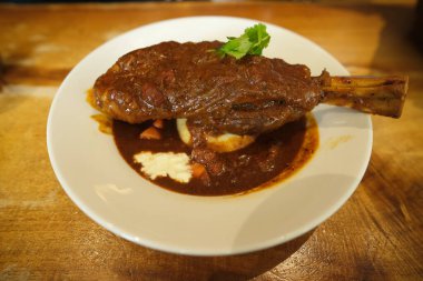 Shallow depth of field special recipe lamb shank in the plate serve during lunch.