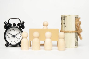 Ofis masasının seçici odak resmi. İçinde oyuncak bebek, çalar saat, sahte para ve bulanık oyuncak bebekler var. İş için doğru adayı seçmek zor bir seçim..