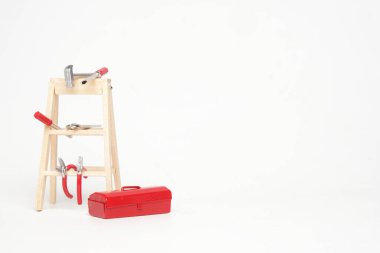 Beyaz arkaplanda araç kutusu, merdiven ve araçların resmi.