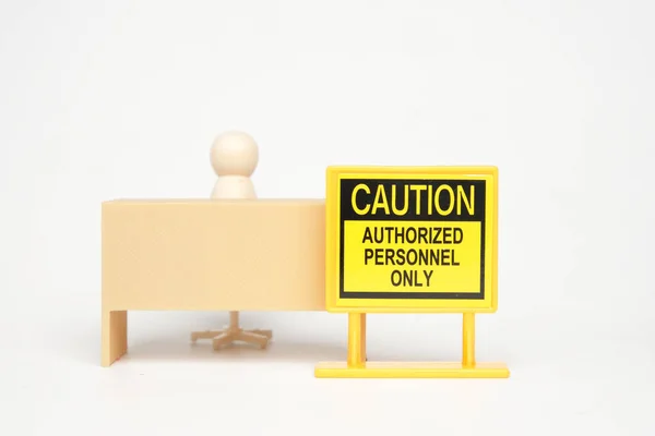 stock image A picture of caution authorized personnel only sign with office desk miniature and peg dolls insight.