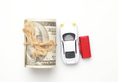 Diyorama arabasının düz bir resmi, minyatür alet kutusu ve beyaz arka planda sahte para. Araba maliyeti ve yükümlülüğü.