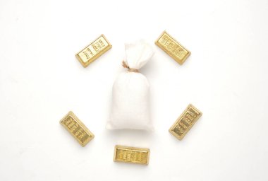 Beyaz arka planda para çantalı mini altın külçeli düz resim.