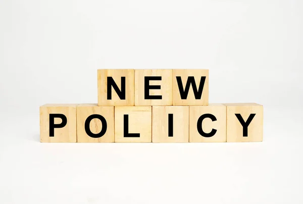 A picture of wooden block written New Policy word on white background.