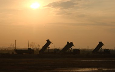 Gün doğumunda gürültü efektli bir kamyon silueti.