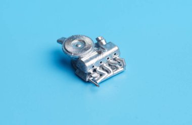 Mavi arkaplanda bir araba motoru minyatürü resmi. 