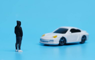 Pahalı araba diyorama görüşü olan minyatür bir adamın resmi. Araba sahipliği kavramı