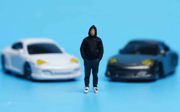 A picture of men miniature with expensive car diorama insight. Car ownership concept