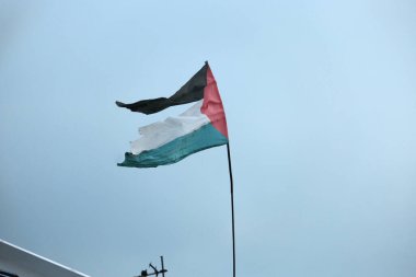 Çatıda yırtık Filistin Bayrağı sallarken çekilmiş bir fotoğraf.