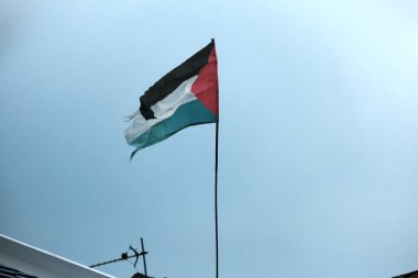 Çatıda yırtık Filistin Bayrağı sallarken çekilmiş bir fotoğraf.