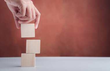 Beyaz masa üzerinde boş ahşap zarları tutan eski model bir el resmi. Metin için boşluk.